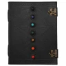 Tagebuch mit Pentagramm und einer Reihe von sieben Chakra-Steinen auf dem Ledereinband